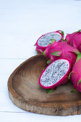 Organic white fresh dragon fruit cut into half on wooden chopping board