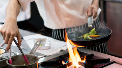 Obraz na płótnie Canvas Chef preparing food in the kitchen, chef cooking, closeup