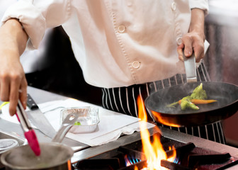 Obraz na płótnie Canvas Chef preparing food in the kitchen, chef cooking, closeup