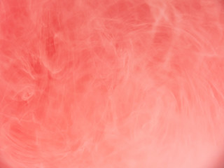 Ink dropped into liquid, abstract background. Close up view. Blurred background. Pink cloud dissolving into water, abstract pattern. Acrylic paint mixing with liquid. Abstract art