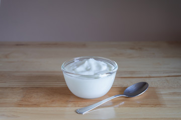 Fototapeta na wymiar Natural homemade plain organic yogurt in bowl on wood texture background