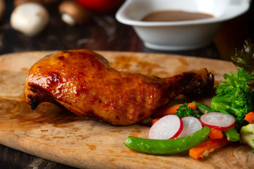 Roast chicken on cutting board with raw ingredients