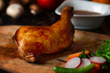 Roast chicken on cutting board with raw ingredients