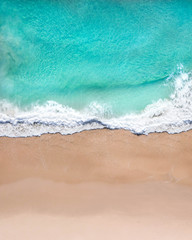 Fototapeta na wymiar Aerial top shot of a beach with nice sand, blue turquoise water and tropical vibe
