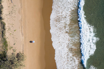Beach aerial view of umbrellas, waves, blues ocean and relaxing vibes