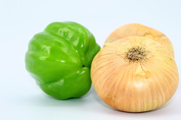 On a light background are vegetables - winter onions, green pepper