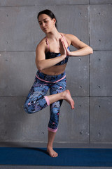 girl in training, doing yoga, performs asana, difficult exercise