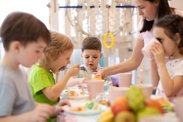 Kids eat festival cake at holiday in daycare