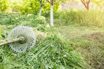 Grass trimmer with a grass in the garden.