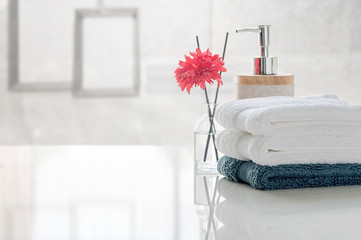Stack of clean towels on white table with blur background of living room, copy space for product display.