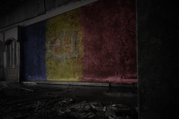 painted flag of andorra on the dirty old wall in an abandoned ruined house.