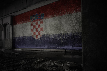 painted flag of croatia on the dirty old wall in an abandoned ruined house.
