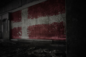 Fototapeta premium painted flag of denmark on the dirty old wall in an abandoned ruined house.
