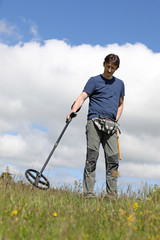 A man searching for buried treasure, ancient coins and historic artefacts with metal detector