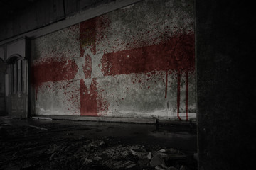 painted flag of northern ireland on the dirty old wall in an abandoned ruined house.