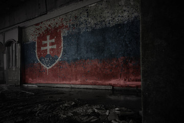 painted flag of slovakia on the dirty old wall in an abandoned ruined house.