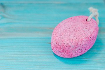 Natural pumice stone with white rope on wooden background.