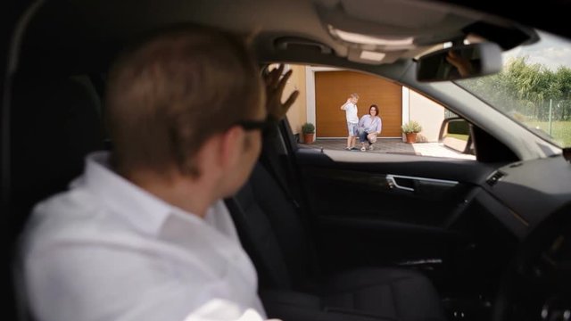 Father dropping off his son at mum's place and waving to them. Happy family concept.