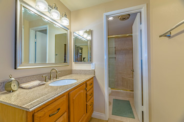 Vanity unit with brown wooden cabinets and bright lights inside a bathroom
