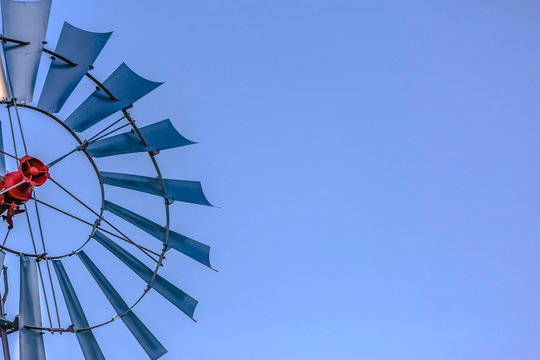 Close up of the multiple blades of a windpump with clear blue sky background