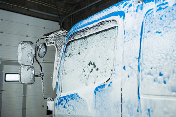 The element of the cab of the blue truck in the lather during washing.