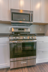 Fototapeta premium Range and wall mounted microwave inside the modern kitchen of a new house