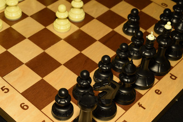 Wooden chessboard under white chessmen as a skill theme