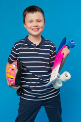 happy boy with a skateboard and a helmet in his hands, laughs, concept of active leisure