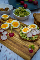 Fototapeta na wymiar Sandwiches with avocado guacamole fresh radish and boiled egg