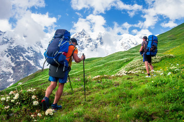 Hiking. Trekking in mountains. People with backpacks in mountain trek. Tourists hike to mountain...
