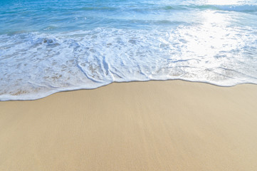 Fototapeta na wymiar Soft wave of blue sea on sandy beach. Background.