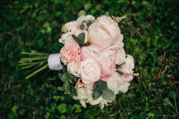 Delicate bridal bouquet with peonies, ranunculus and roses
