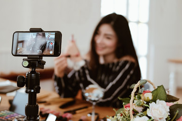 beauty blogger live broadcasting cosmetic makeup tutorial on social media.