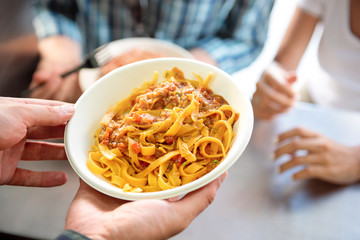 Street food pasta in  take away paper plate being served to customer