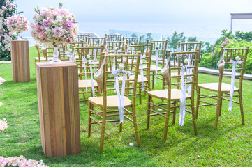 Wedding ceremony. Arch, decorated with flowers on the lawn, beach background, sea in summer.