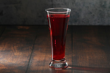 Red juicy drink in a high beer glass