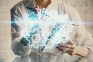 International business hud over woman's hands writing background. Concept of hard work. Double...
