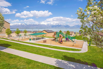 Playground and picnic area with homes lake and mountain in the background