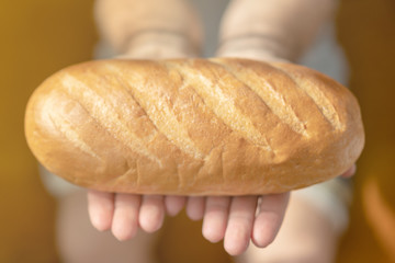 Male hands holding freshly baked wheaten bread closeup