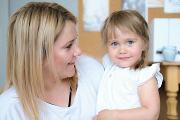 Mother and daughter. A young blonde woman with her beautiful little daughter. The girl has blue eyes and blonde braids.