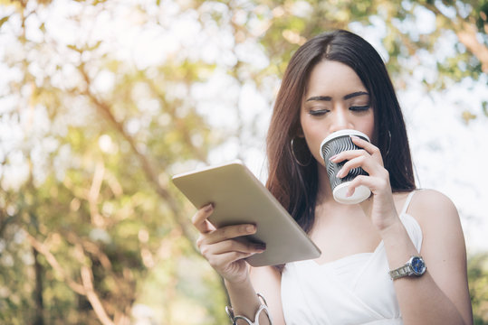 Woman Reading Online Article & Explore Online Feminist Website from tablet  and drinking coffee. Searching Blog, Content to find Best Literary Fiction Websites. Smart woman's reading conceptual image