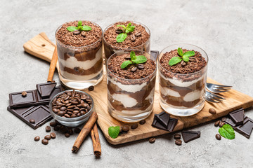 Classic tiramisu dessert in a glass on dark concrete background