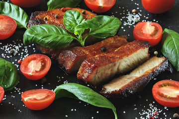 Fresh appetizing meat steak on a board with tomatoes and basil. Keto diet. Paleo diet. Pegan Diet.