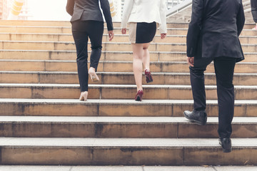 Young active business people walking up stair to go to work in modern city. Crowded group of people in big city lifestyle with briefcase, smart phone, cup of coffee. Business Lifestyle Concept.