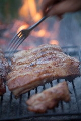 Grilled barbeque port. Cooking outdoor. Marinated grilled ribs. Summer picnic. Cooking dinner. Spareribs Ribs Close-up On The Hot Flaming Grill.
