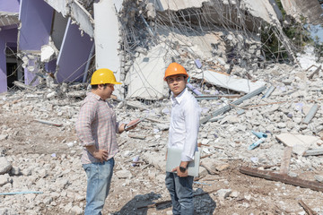 Engineer and architect shaking hands and worker operation control demolish old building.