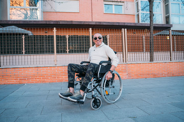 Obraz premium grandfather sitting on a wheelchair outdoor