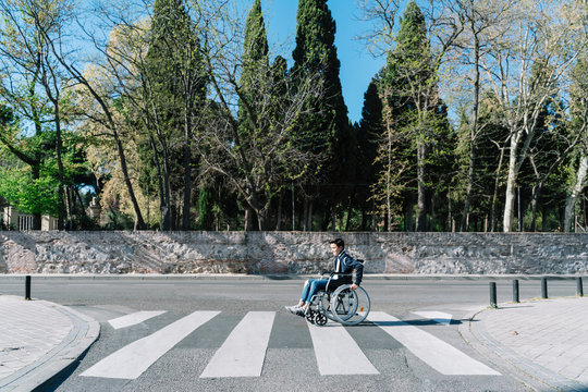 Little boy in wheelchair crossing the street.