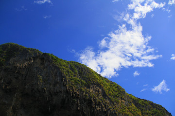 Mountain rock in middle of sea with blue sky and cloud, very happy every time when seeing.