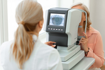 Focused ophthalmologist using computer technologies while screening